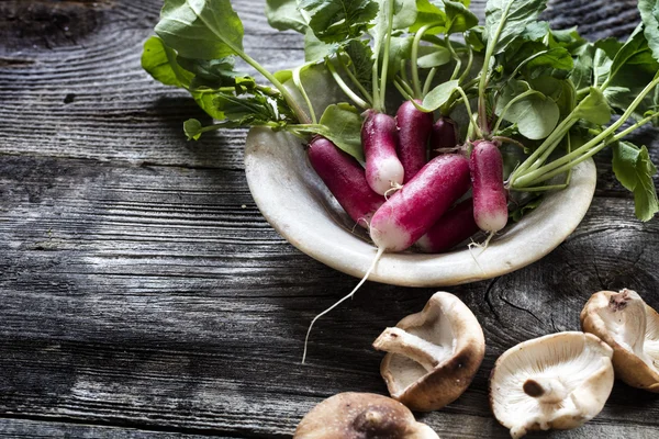 Radishes and mushrooms on old wooden for vegetarian home-made cuisine — Stock Photo, Image