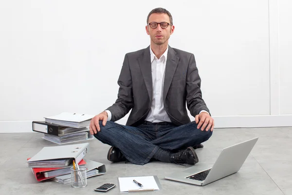 Безмятежный бизнесмен медитирует в офисе, делая перерыв в работе над бюджетом — стоковое фото