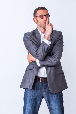 stratejik sessizlik ve iş takdiri için dudaklarında parmak ile ayakta oynak 40s erkek yönetici