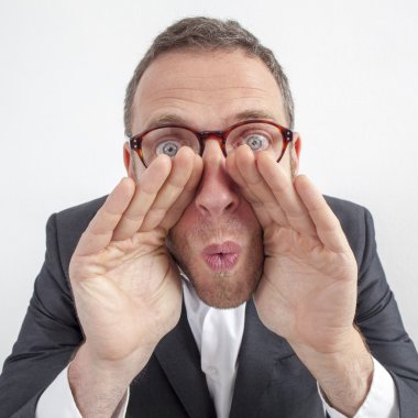 kendinden geçmiş 40'lı yaşlardaki adam kontrol edilmiş gömlekli bir şeye bakıyor.