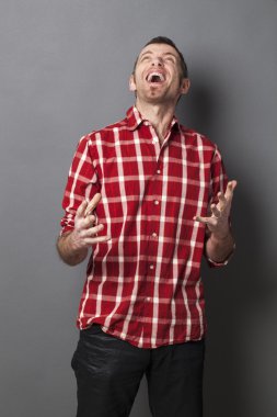 kendinden geçmiş 40'lı yaşlardaki adam kontrol edilmiş gömlekli bir şeye bakıyor.