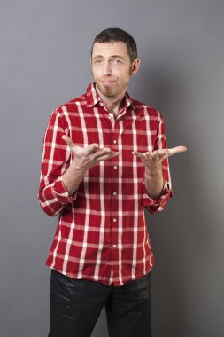 kendinden geçmiş 40'lı yaşlardaki adam kontrol edilmiş gömlekli bir şeye bakıyor.