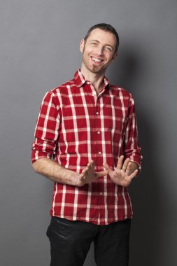 excited 40s man with checked shirt pointing finger to show something on side