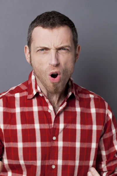 Hombre de 40 años extático con camisa a cuadros mirando algo cayendo hacia él — Foto de Stock