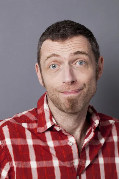 excited 40s man with checked shirt pointing finger to show something on side