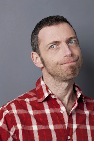 Excited 40s man with checked shirt pointing finger to show something on side — Stockfoto