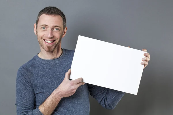 Sonriente hombre de 40 disfrutando de hacer un anuncio en la visualización de un inserto en blanco — Foto de Stock