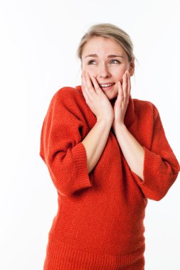 neşeli güzel genç sarışın kadın turuncu kış kazak sevinç ve zevk için yüzüne dokunarak