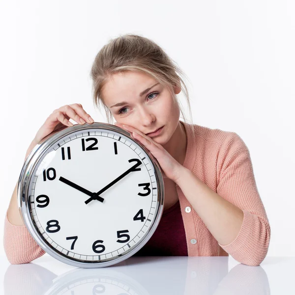 Sad beautiful young blond woman leaning on a clock, showing depressing nostalgia of adolescence — Zdjęcie stockowe