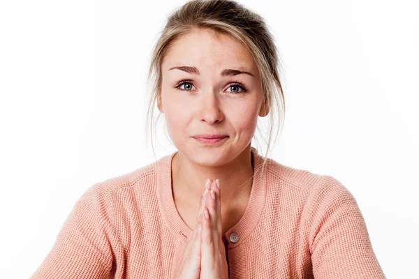 Primer plano de la joven rubia rezando sonriendo, tocando ambas manos para la paciencia y la suavidad —  Fotos de Stock