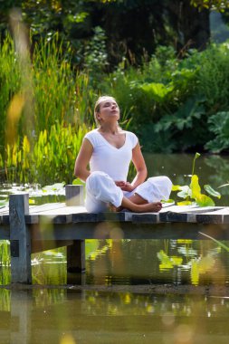 açık havada gevşeme - zen 20s sarışın kadın nefes, su ortamı