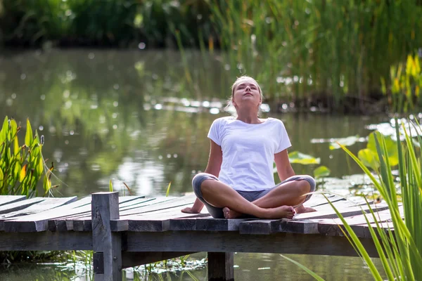 Zen 20s blond girl breathing, pond environment — Stock Photo, Image