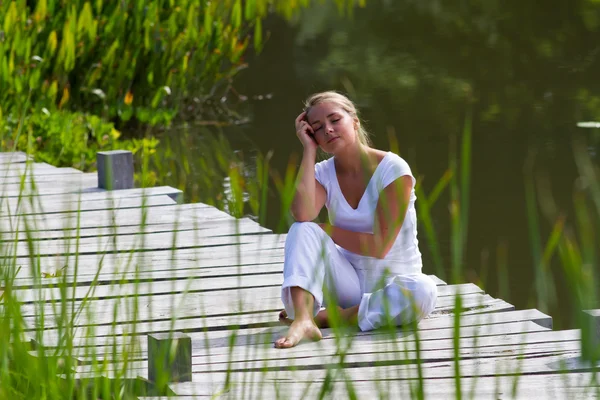 Relaks na zewnątrz-20s blond kobieta relaks i marzenia w pobliżu wody — Zdjęcie stockowe