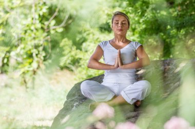 açık havada meditasyon - zen 20s sarışın kız büyük bir taş üzerinde meditasyon