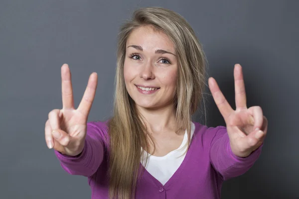 Concept de succès - heureuse fille des années 20 montrant un double signe de victoire au premier plan — Photo