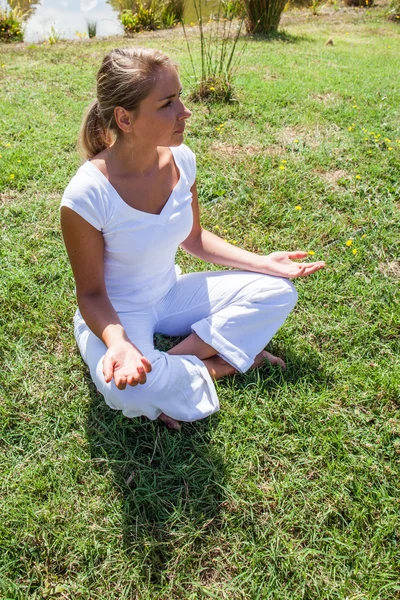 Splendida 20s bionda ragazza meditando in verde surrondings — Foto Stock