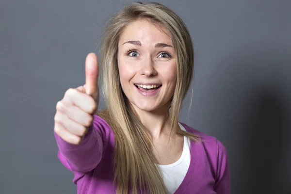 Sorridente mulher de 20 anos com o polegar para cima em primeiro plano — Fotografia de Stock