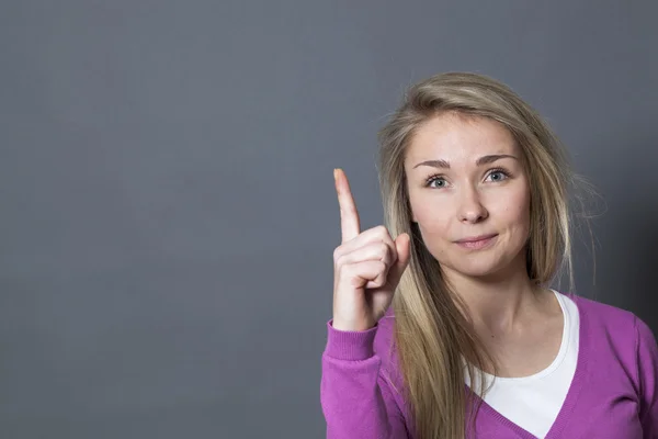 Lycklig ung kvinna höjer fingret för att tala upp med ljusa idéer — Stockfoto