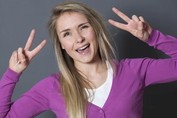 Emocionada mujer de 20 años mostrando 2 signos de victoria — Foto de Stock