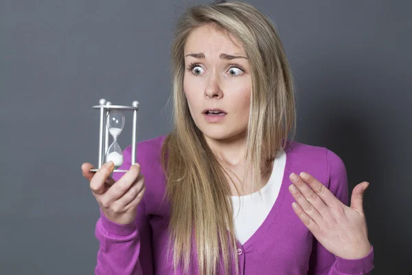 Bedwelmd 20s meisje met symbool van timing en termijnen in handen — Stockfoto