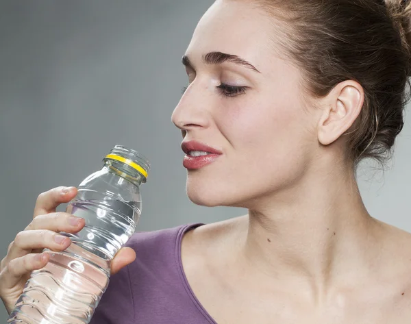 20s menina bebendo água fresca zesty no estúdio — Fotografia de Stock