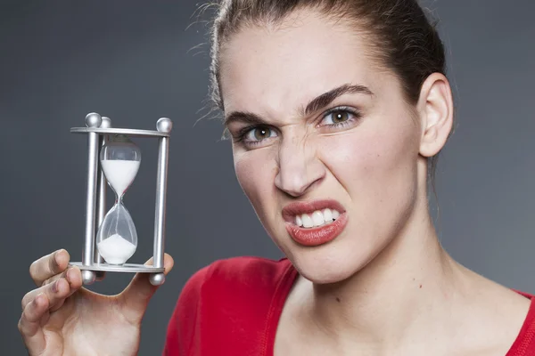 20er-Jahre-Mädchen mit Symbol für Timing und Fristen in Händen bedroht — Stockfoto