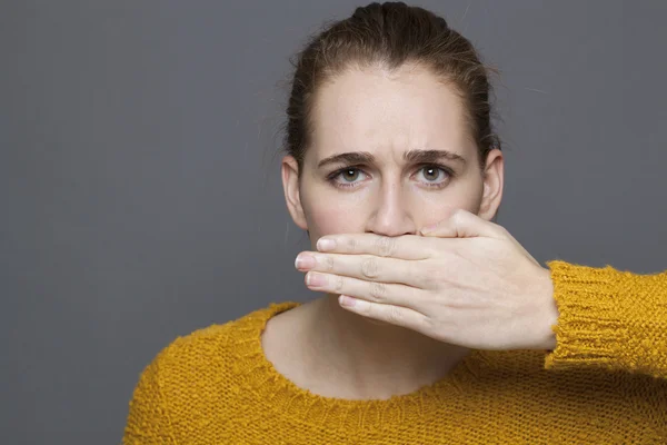 Portrait of unhappy young woman covering her mouth for frustration — Stock Photo, Image