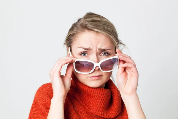 Chica deprimida mirando por encima de las gafas de sol grandes que sufren de azules de invierno — Foto de Stock