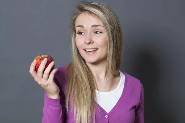 Oskyldiga leende 20s flicka håller aptitretande apple med lust — Stockfoto