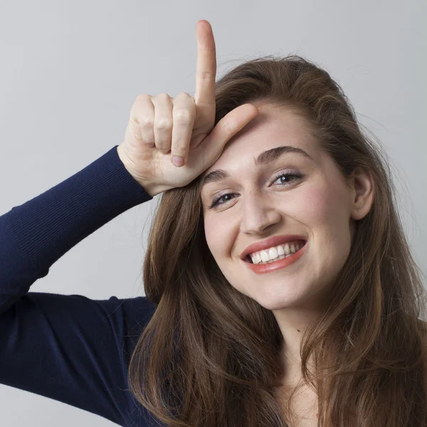 Emocionada joven mujer haciendo el signo de perdedor L en la frente — Foto de Stock