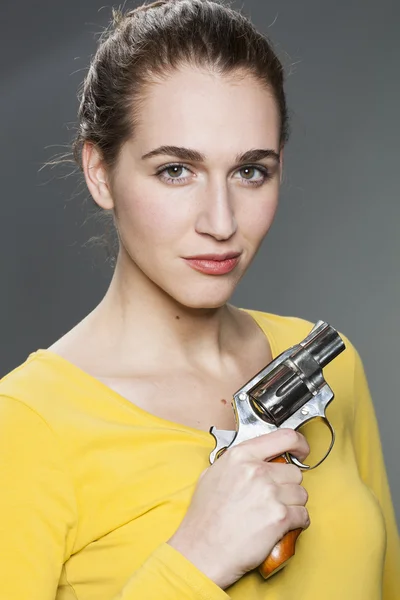 Pretty female teenager holding a fake gun to play gangster — Zdjęcie stockowe