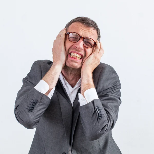 Gritando hombre de negocios de mediana edad protegiendo sus oídos contra el dolor de cabeza — Foto de Stock