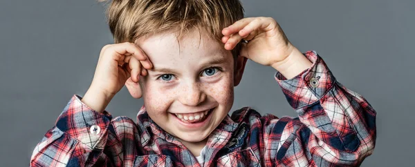 Fräcka manliga förskolebarn med fräknar leker med sina händer — Stockfoto