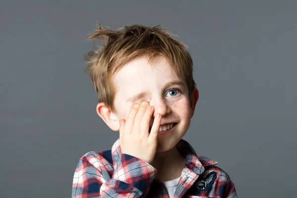 Mosolygós vörös hajú gyermek bujkál a szórakozás egy szem látás — Stock Fotó