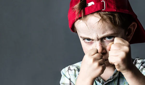 Amenazante chico con pecas y sombrero rojo espalda buscando violento —  Fotos de Stock