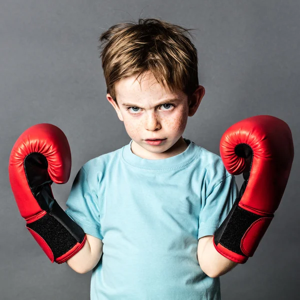 Infeliz preescolar con el pelo rojo mostrando sus guantes de boxeo —  Fotos de Stock