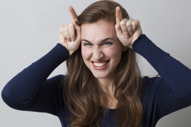 arsız işareti için çift parmak boynuzlarıyla kendinden geçmiş genç kadın