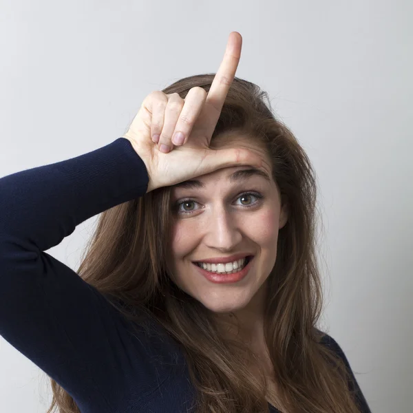 Sorprendida joven mujer haciendo el signo de perdedor L en la frente —  Fotos de Stock