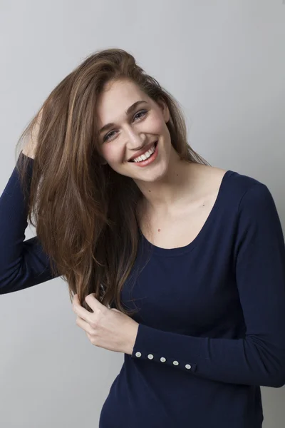 Bonita menina de 20 anos brincando com seu cabelo longo com felicidade — Fotografia de Stock
