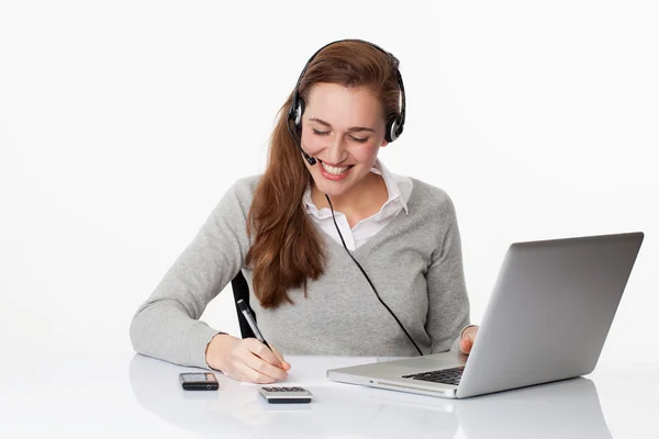 Cheerful 20s professional with headset and computer in white office Royalty Free Stock Images