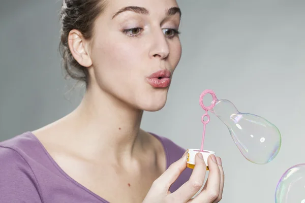 Speelse 20 's meisje blazen van zeepbellen voor plezier en verbeelding — Stockfoto