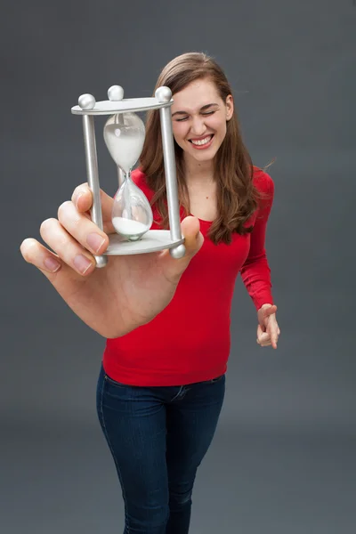 Ενθουσιασμένος νεαρή γυναίκα με μια ώρα γυαλί σε μεγάλου μεγέθους χέρι — Φωτογραφία Αρχείου