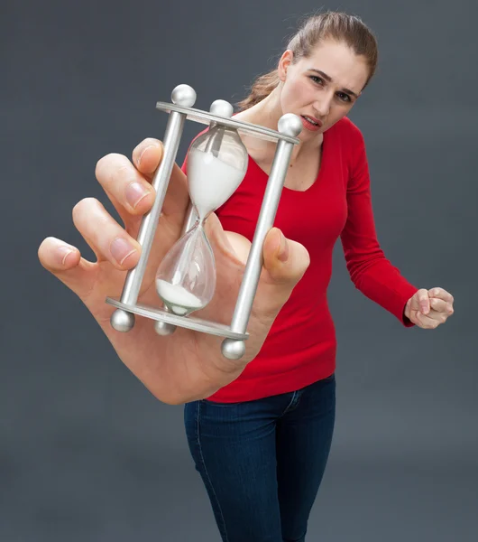 Dubieuze mooie jonge vrouw die houdt van een zandloper tegen stress — Stockfoto