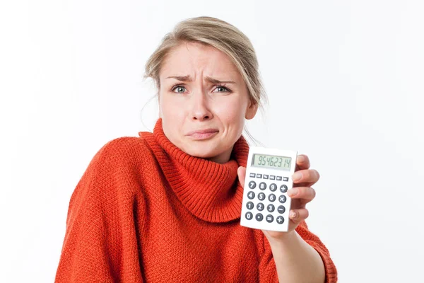 Mujer joven disgustada sosteniendo una calculadora por miedo o matemáticas — Foto de Stock