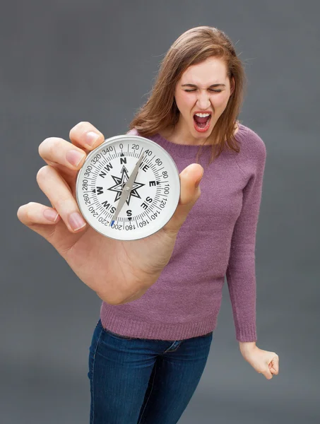 Crier belle jeune femme ayant la colère avec une grosse boussole — Photo