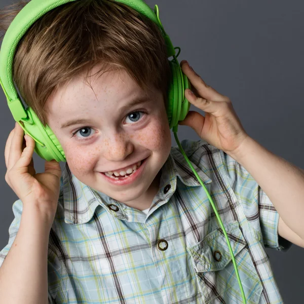そばかすが笑い、音楽を聴いているいたずらな小さな子供 — ストック写真