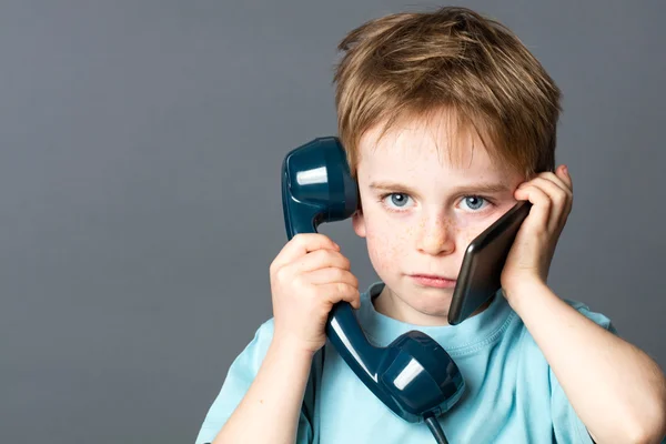 Καταπονημένο νεαρό παιδί που επικοινωνεί με νέα και παλιά τηλέφωνα — Φωτογραφία Αρχείου