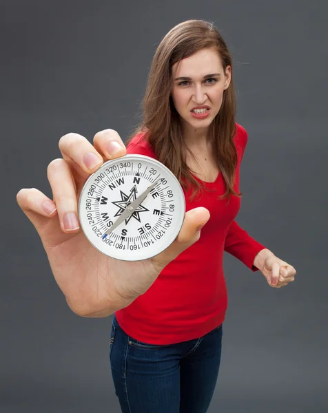 Boze jonge vrouw intimiderend met een oversized kompas — Stockfoto