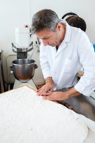 Acabamento de especialidade nougat por pastelaria cozinheiro na cozinha industrial — Fotografia de Stock