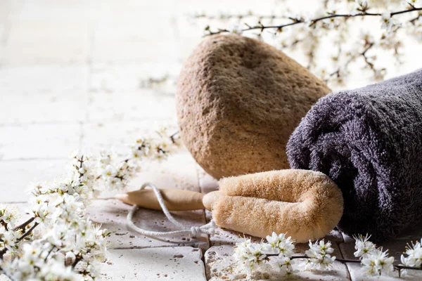 Loofah and towel over fresh flowers for exfoliation spa treatment — Stock Photo, Image